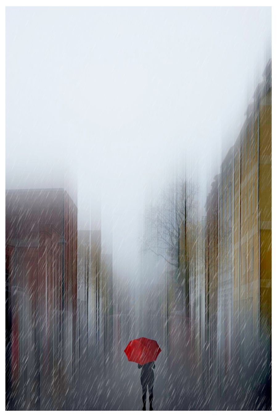 Eine Frau mit einem roten Regenschirm. Sie steht im Regen.